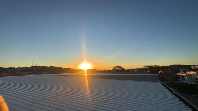 Telhado de aluzinco em residência ao pôr do sol
